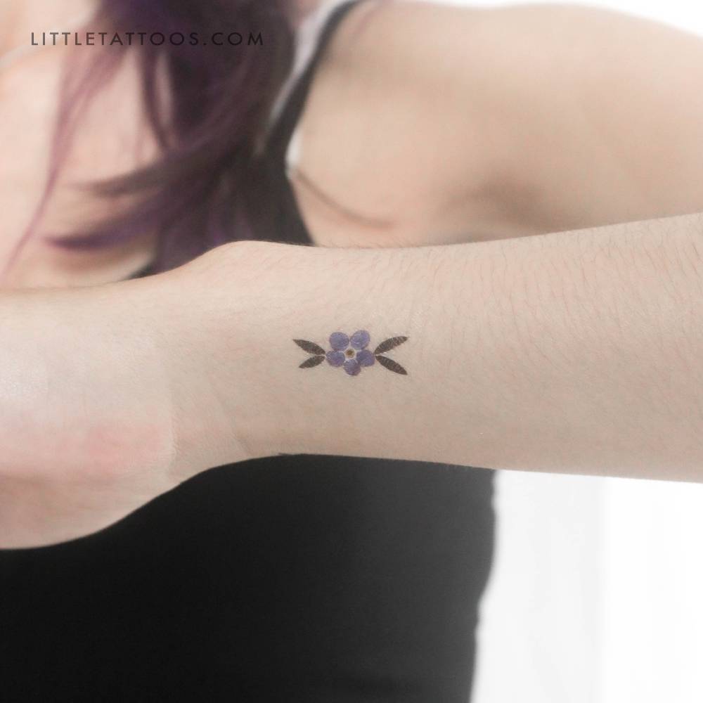 Watercolor style forget-me-not temporary tattoo located on the wrist.