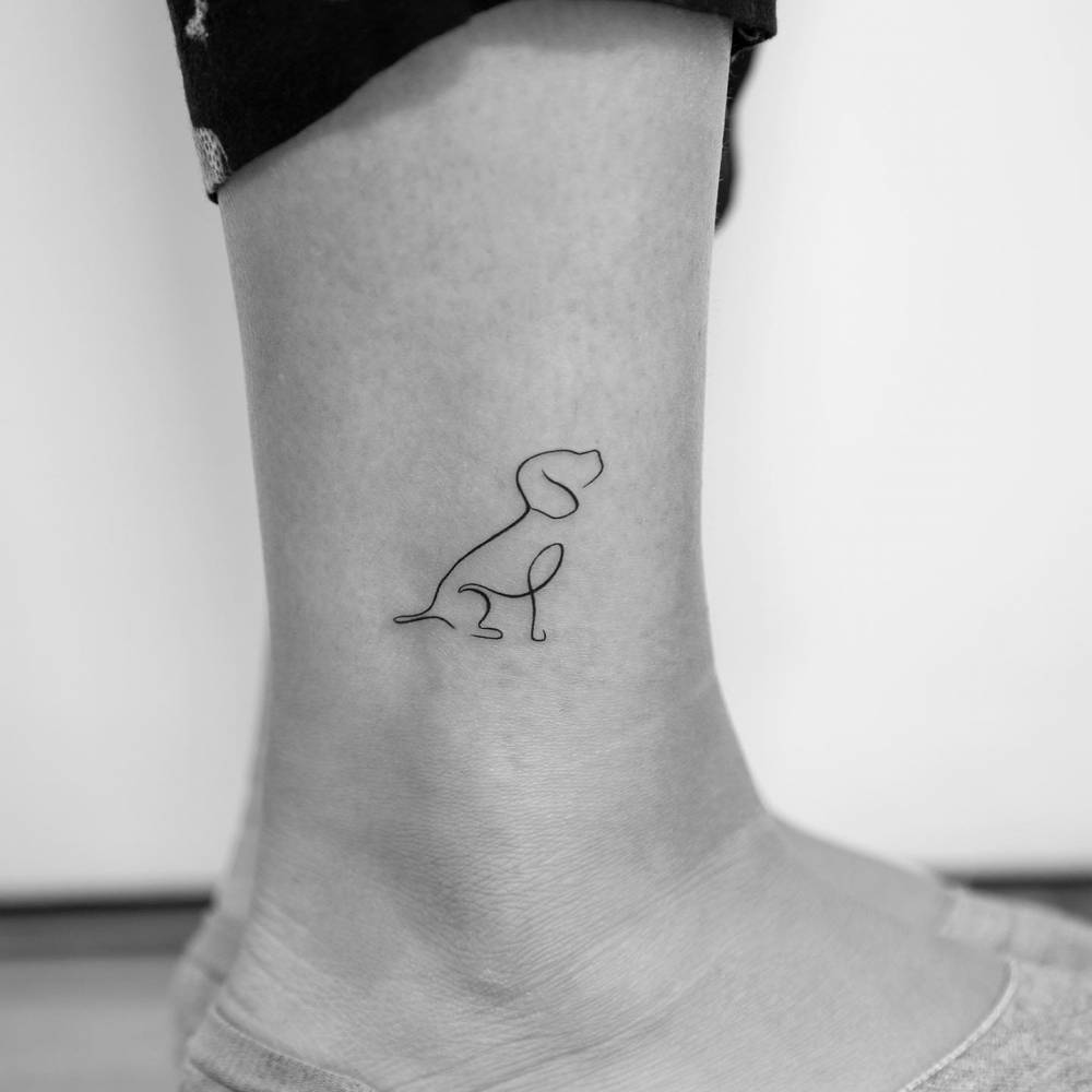 Minimalistic style beagle tattoo located on the ankle.