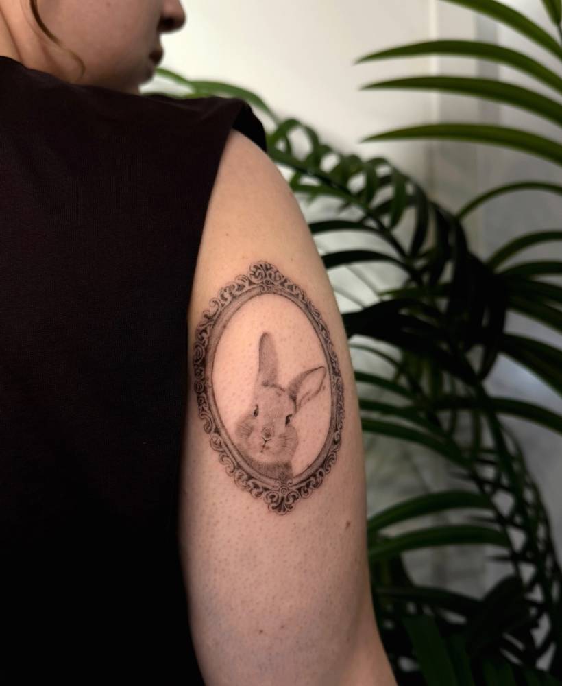 Micro-realistic style rabbit portrait tattoo located on the tricep.