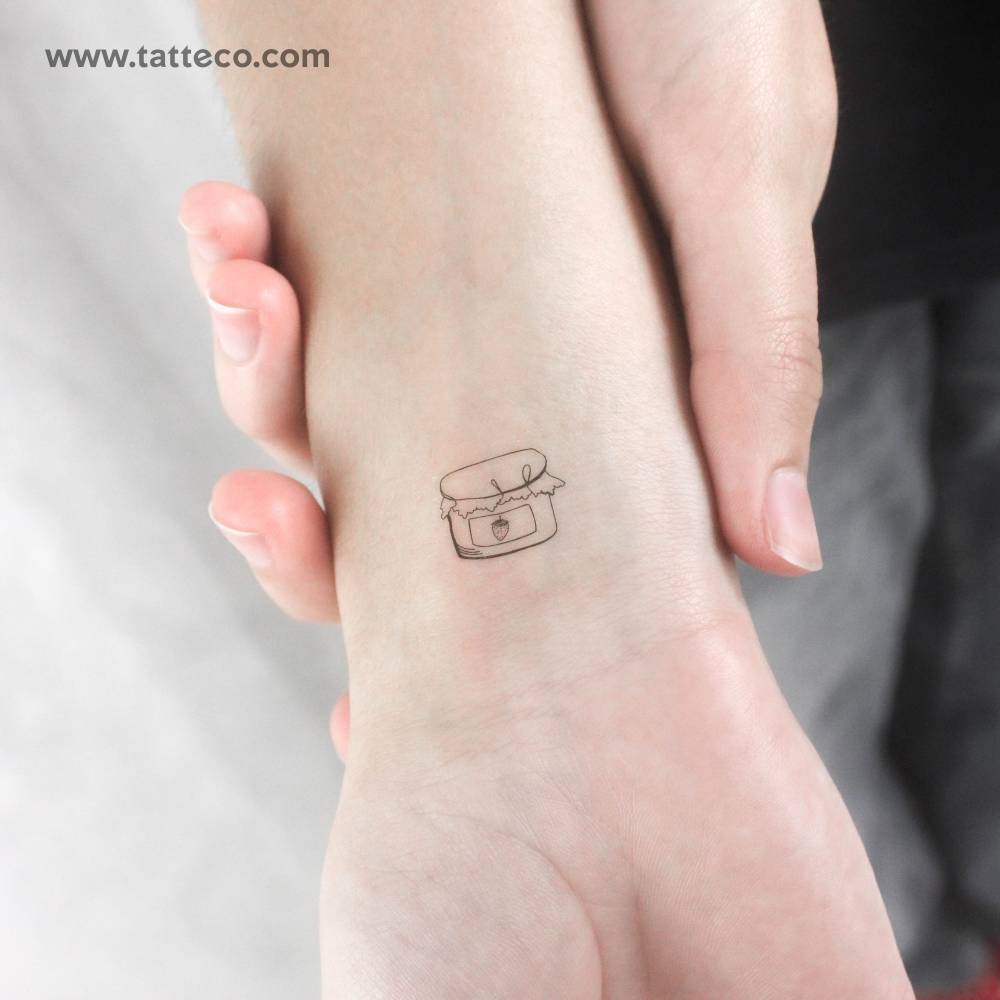 Fine line style strawberry jam temporary tattoo located on the wrist.