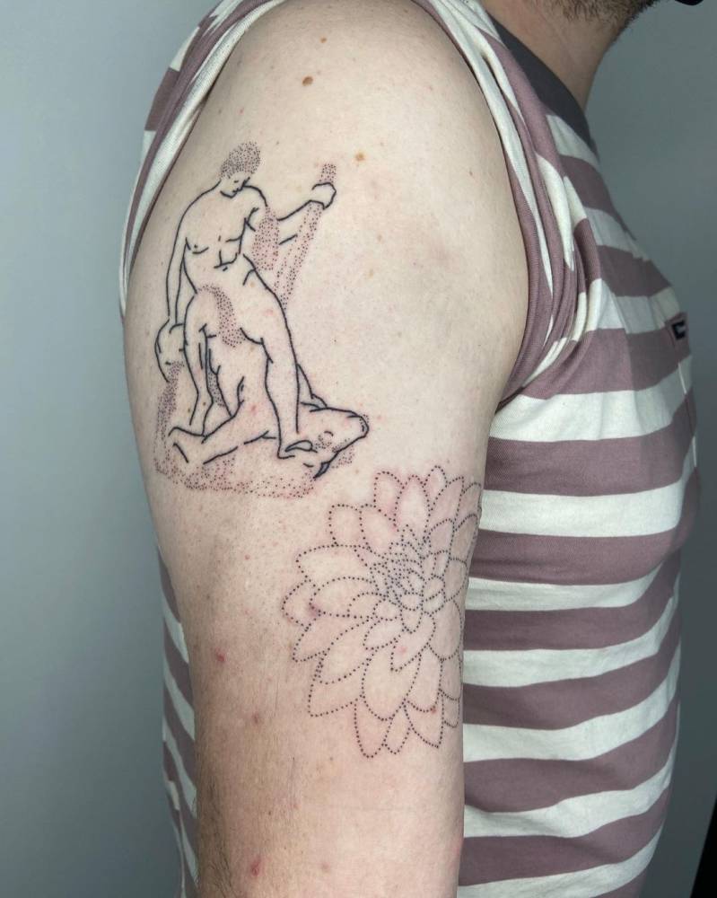 Hand poked Theseus and the Minotaur + flower tattoo on the upper arm