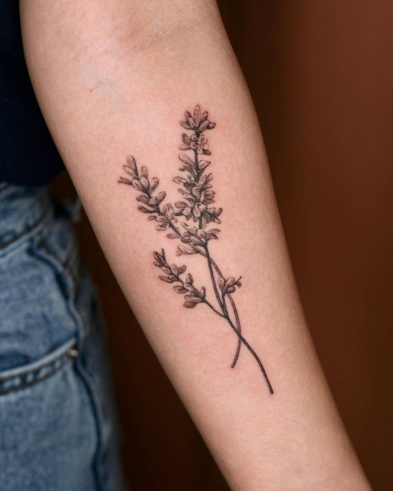 Watercolor style lavender tattoo located on the inner forearm.