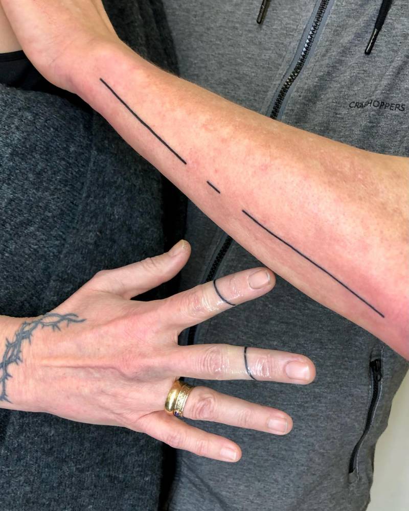 Matching minimalistic lines tattooed on couple.
