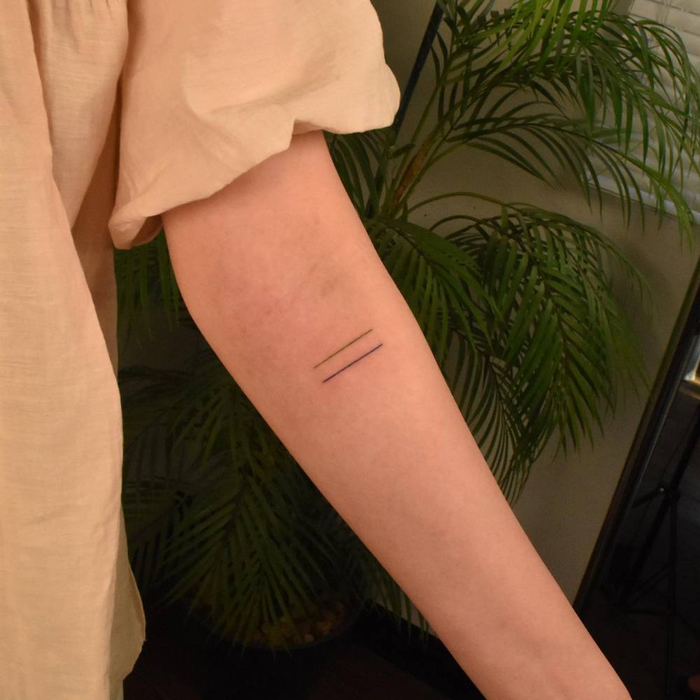 Minimalistic style lines tattoo located on the inner forearm.