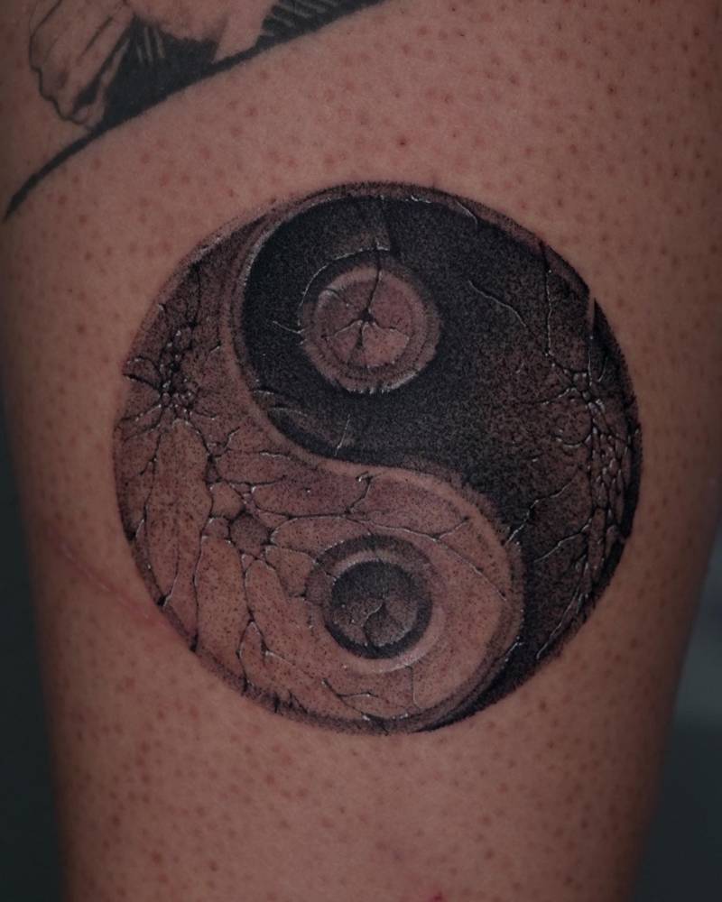 Yin Yang tattoo in black and grey style located on the calf.