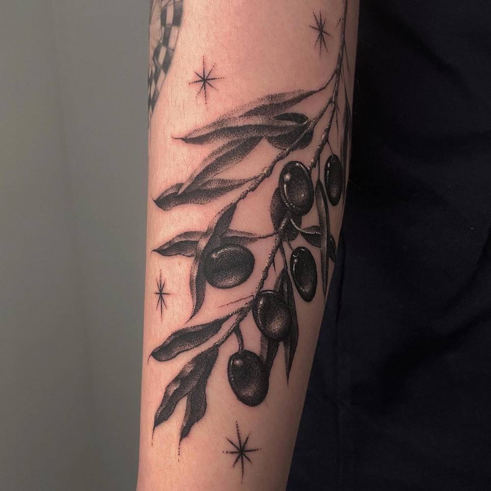 Dotwork style olive branch tattoo located on the upper arm.