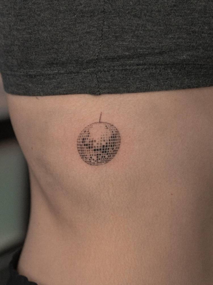 Disco ball tattoo in illustrative style done on the rib.