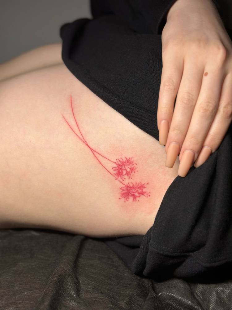 Red spider lily tattoo located on the rib, illustrative style.