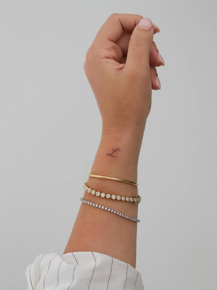 Little letter "L" tattoo located on Amanda Hirsch's wrist.