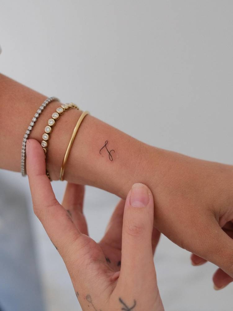 Little letter "L" tattoo located on Amanda Hirsch's wrist.