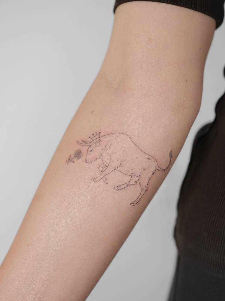 Bull tattoo in fine line style located on the inner forearm.