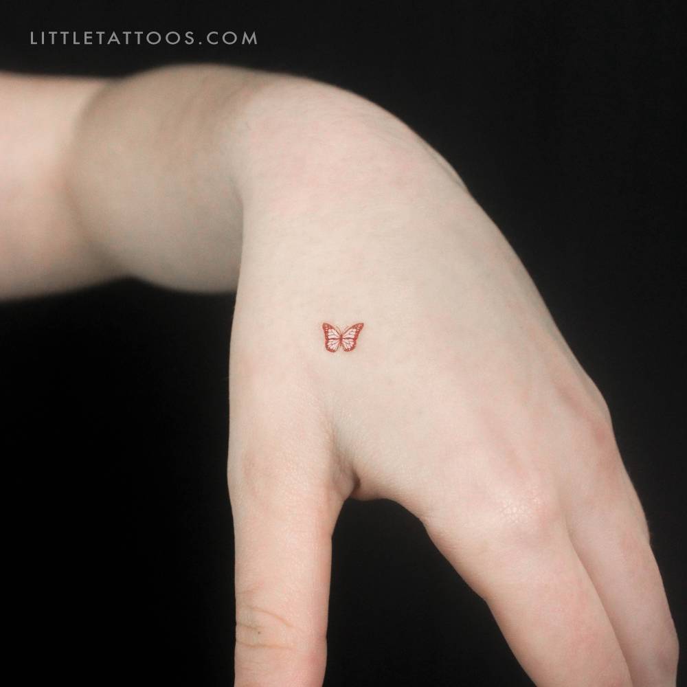 Red butterfly temporary tattoo located on the hand.