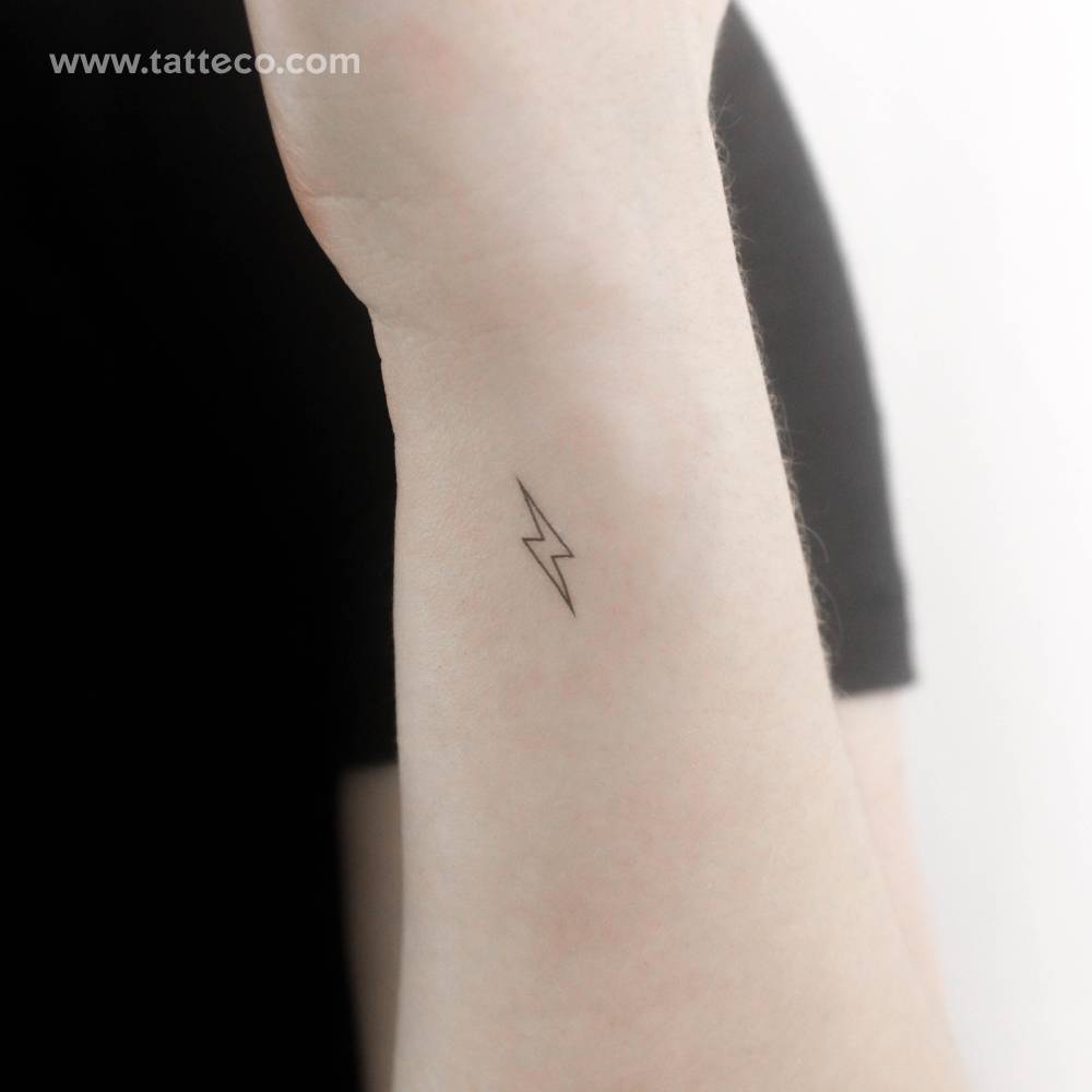 Small lightning bolt outline temporary tattoo located on the wrist.