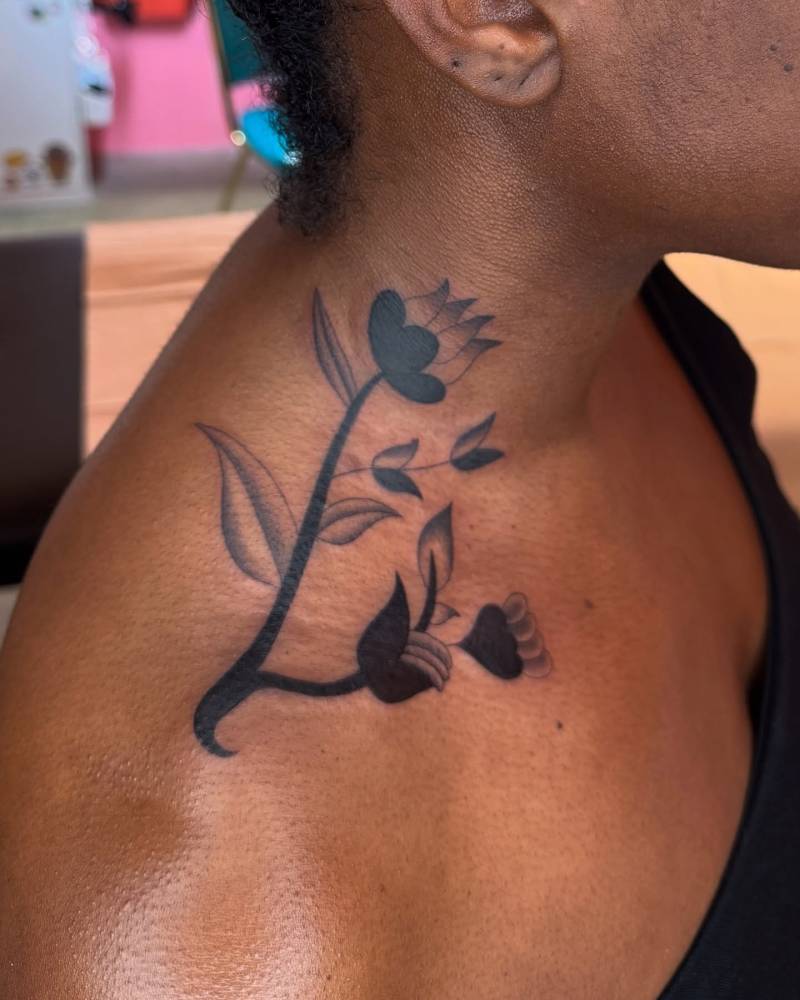 Blackwork style flowers tattoo located on the top of shoulder.