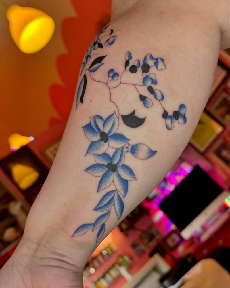Illustrative style flowers tattooed on the inner forearm.