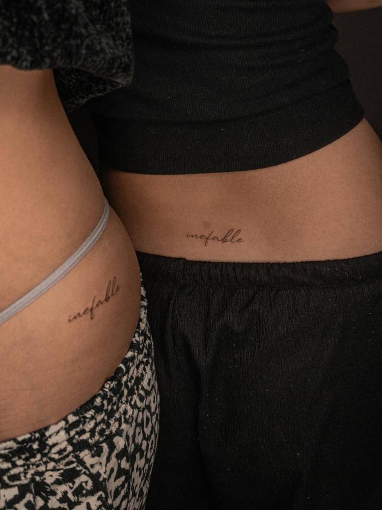 Matching lettering tattoo of the word "inefable" for best friends.