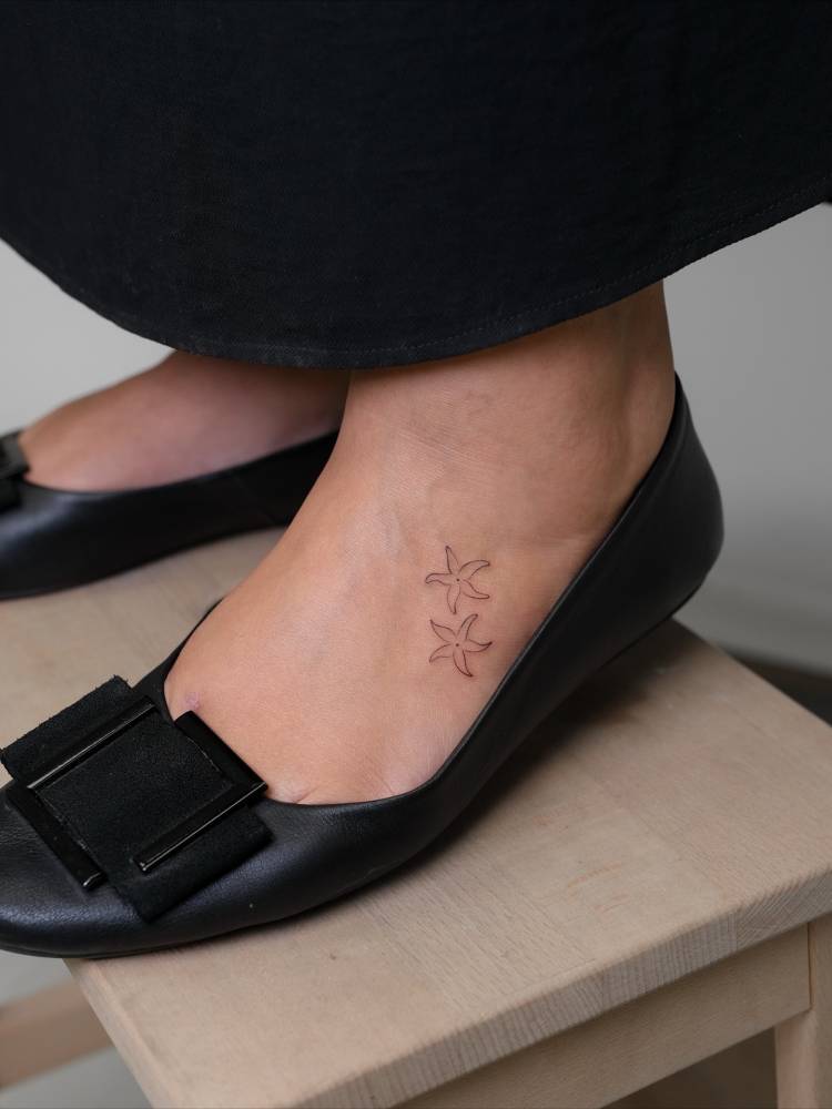 Fine line style starfish tattoo located on the foot.