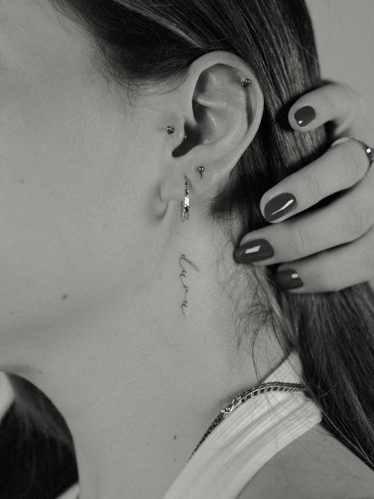 Script font name "Duru" tattooed on the neck.