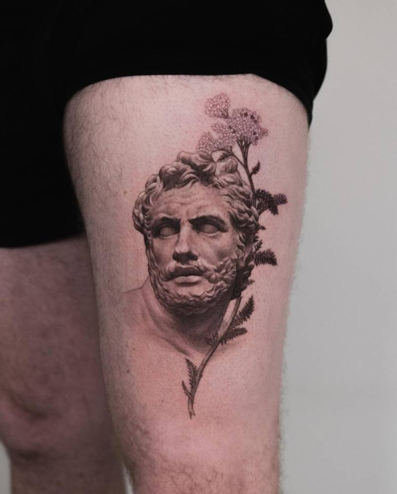 Patroclus tattoo in black and grey style located on the thigh.