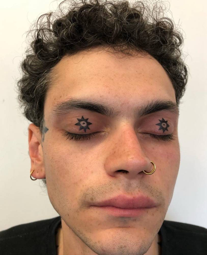 Stars tattoo in blackwork style located on the eyelids.