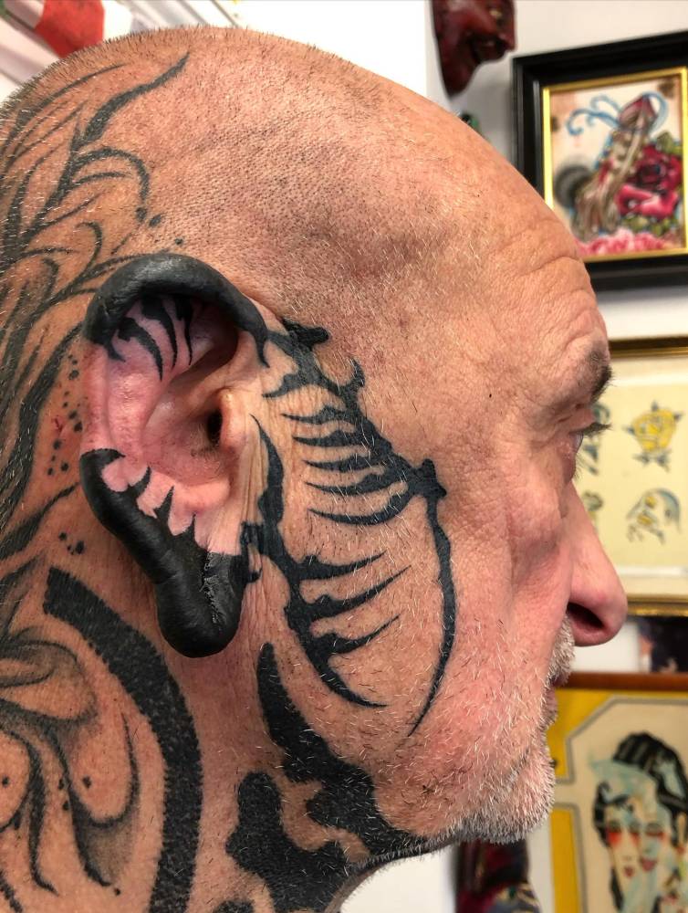 Tribal design tattooed on the ear and face.