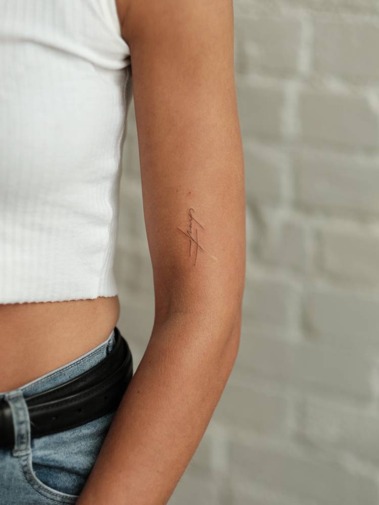 Signature tattoo located on the upper arm.