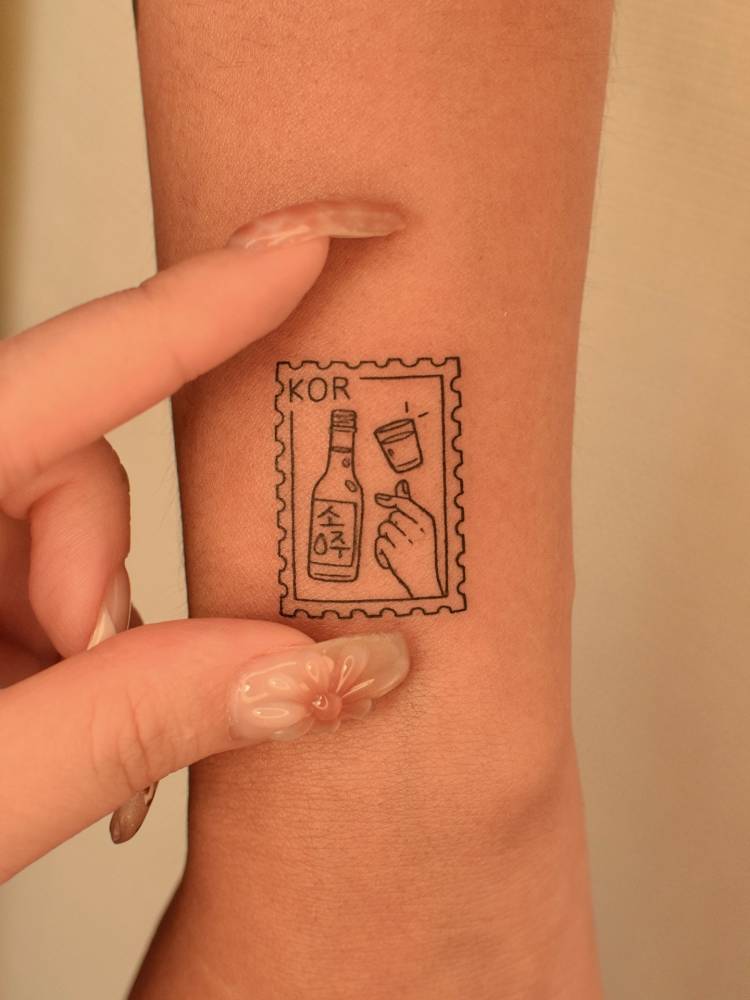 Soju stamp tattoo located on the wrist.