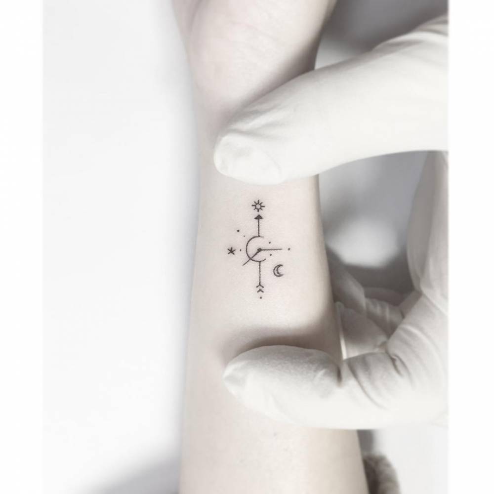 Compass rose tattoo in minimalistic style located on the wrist.