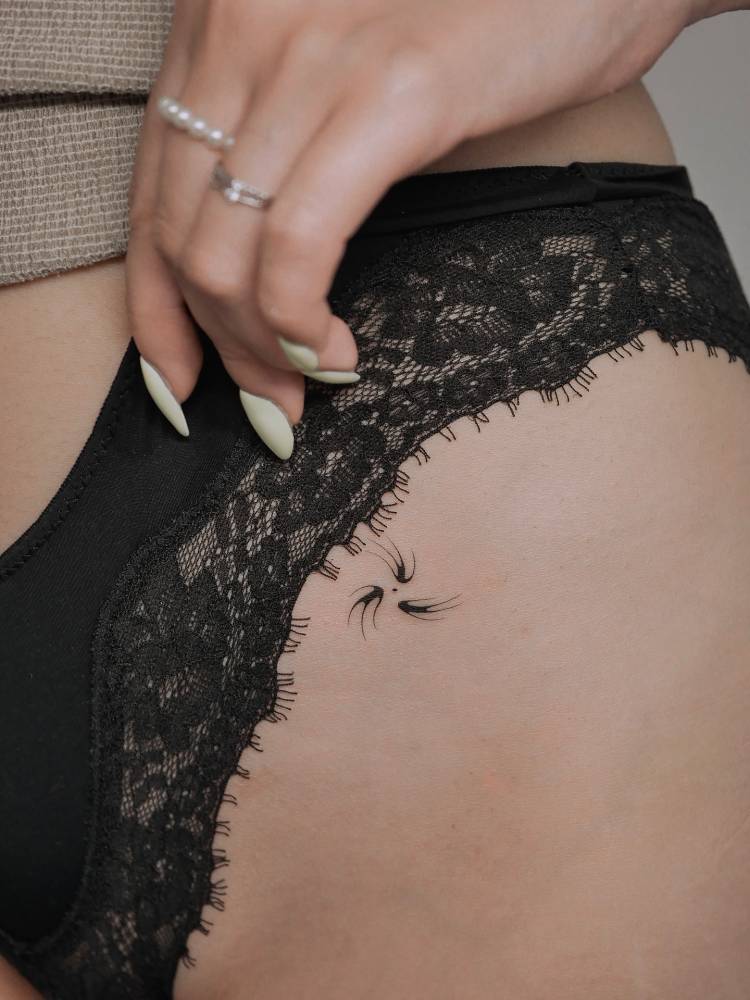 Minimalistic ornamental design tattooed on the pelvis.
