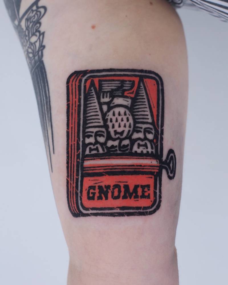 Canned gnomes tattoo located on the inner arm.