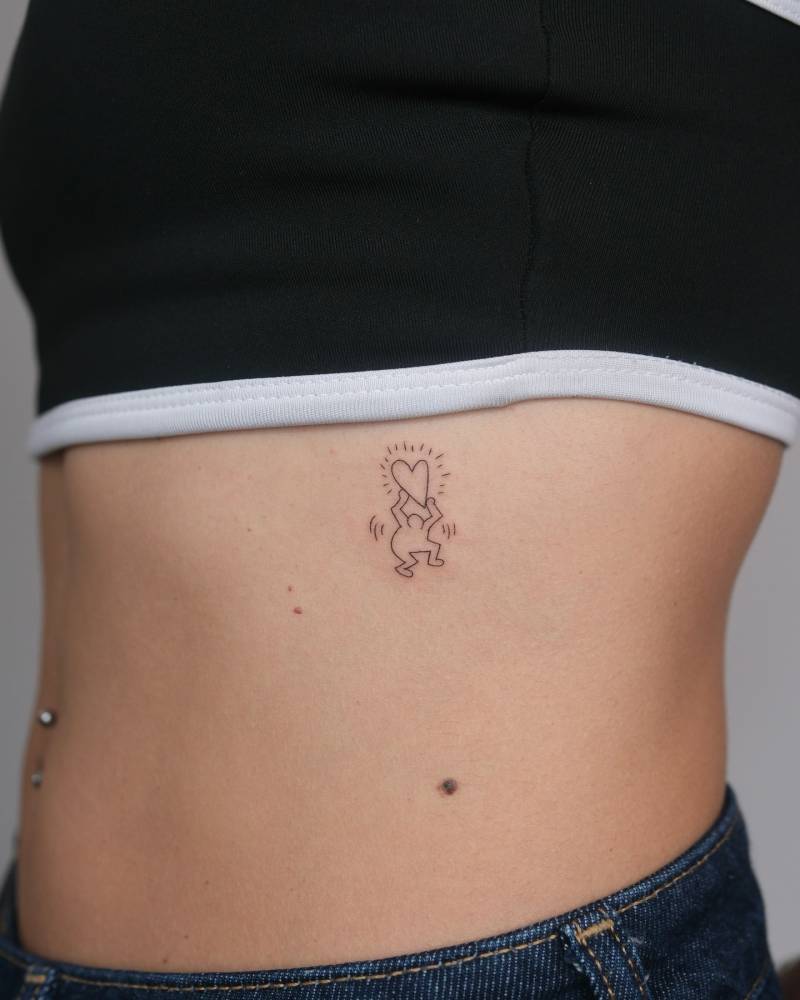 Fine line style Keith Haring's artwork tattoo located on the rib.