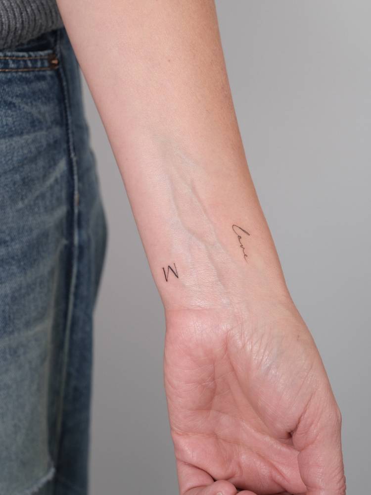 Letter "M" and word "love" tattooed on the wrist.