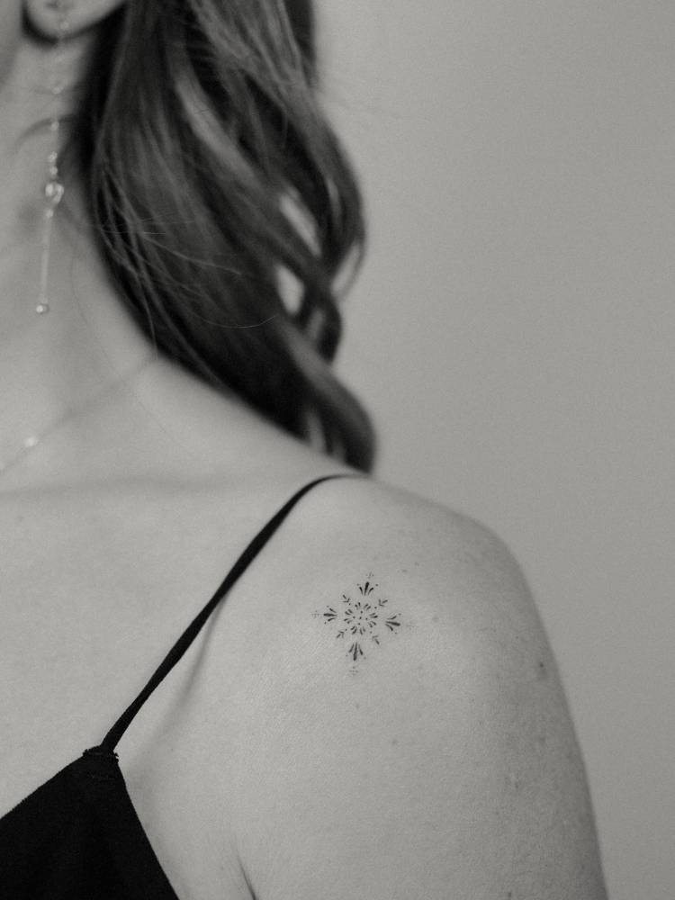 Fine line style ornamental design tattooed on the shoulder.