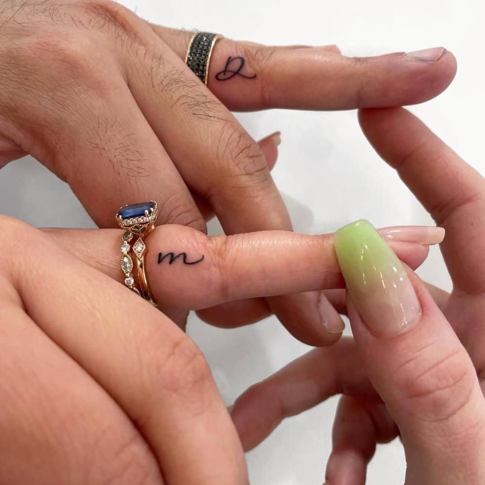 Matching letters "D" and "M" tattoos for couple.