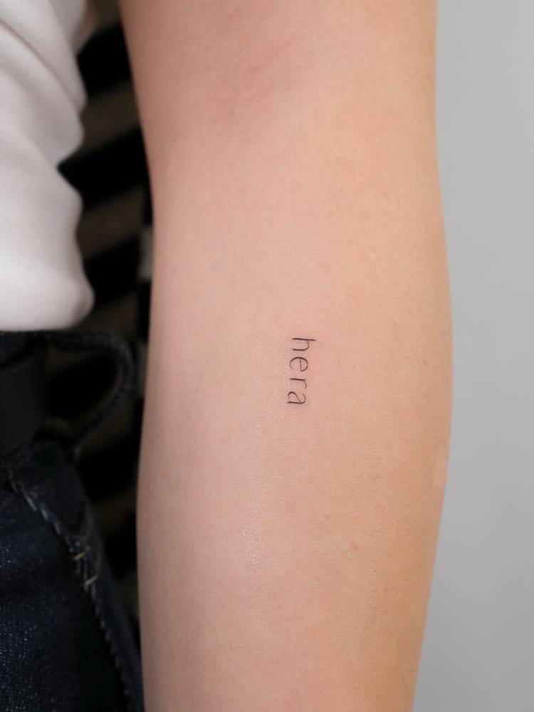 Lettering tattoo on the name "hera" located on the forearm.