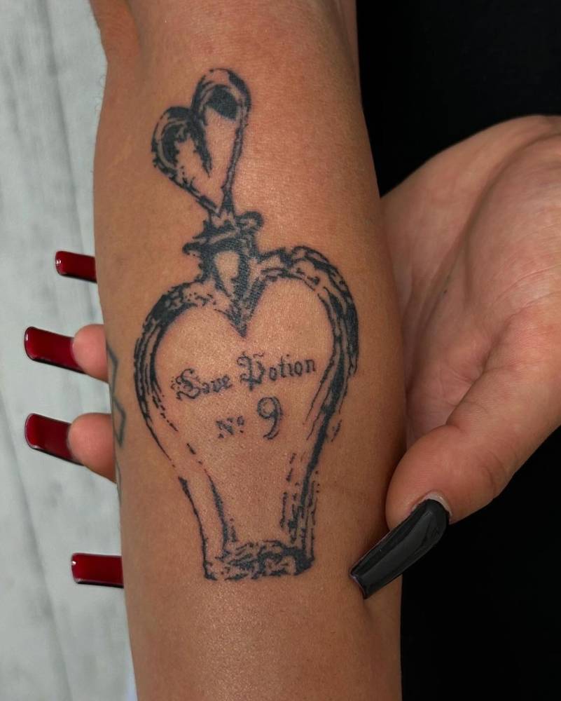 Love potion tattoo in blackwork style located on the forearm.