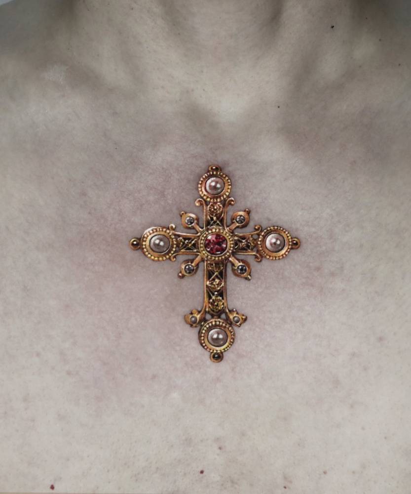 Micro-realistic style Christian cross tattoo located on the chest.