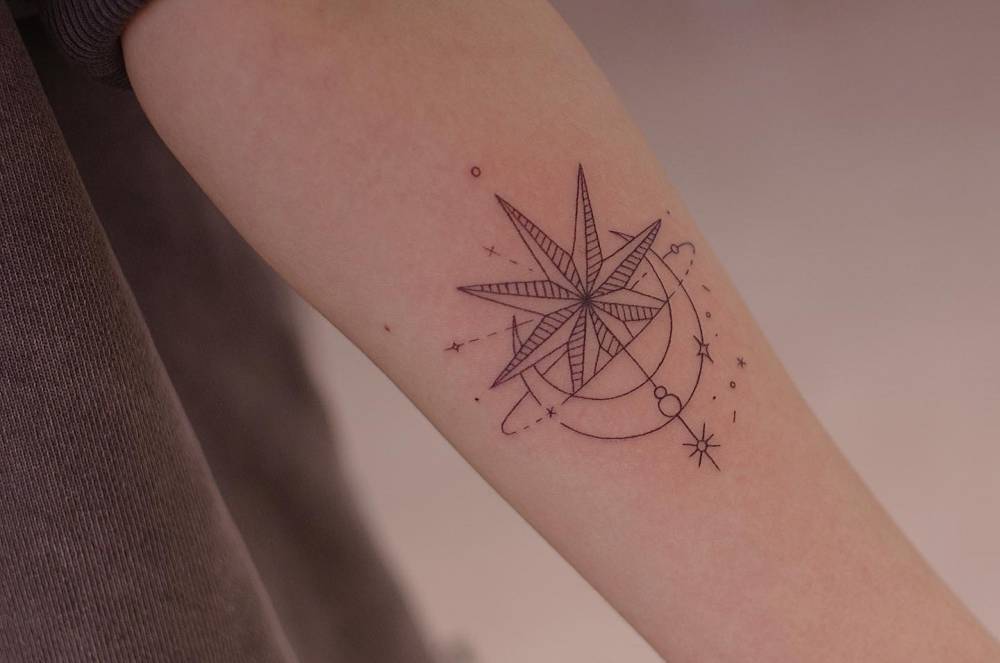 Fine line style ornamental star tattoo located on the inner forearm.