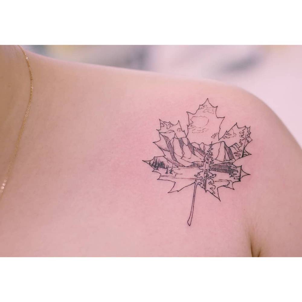 Maple leaf and mountains tattoo located on the shoulder.