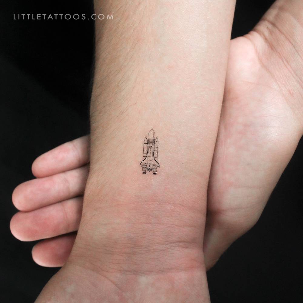 Tiny space shuttle temporary tattoo located on the wrist.