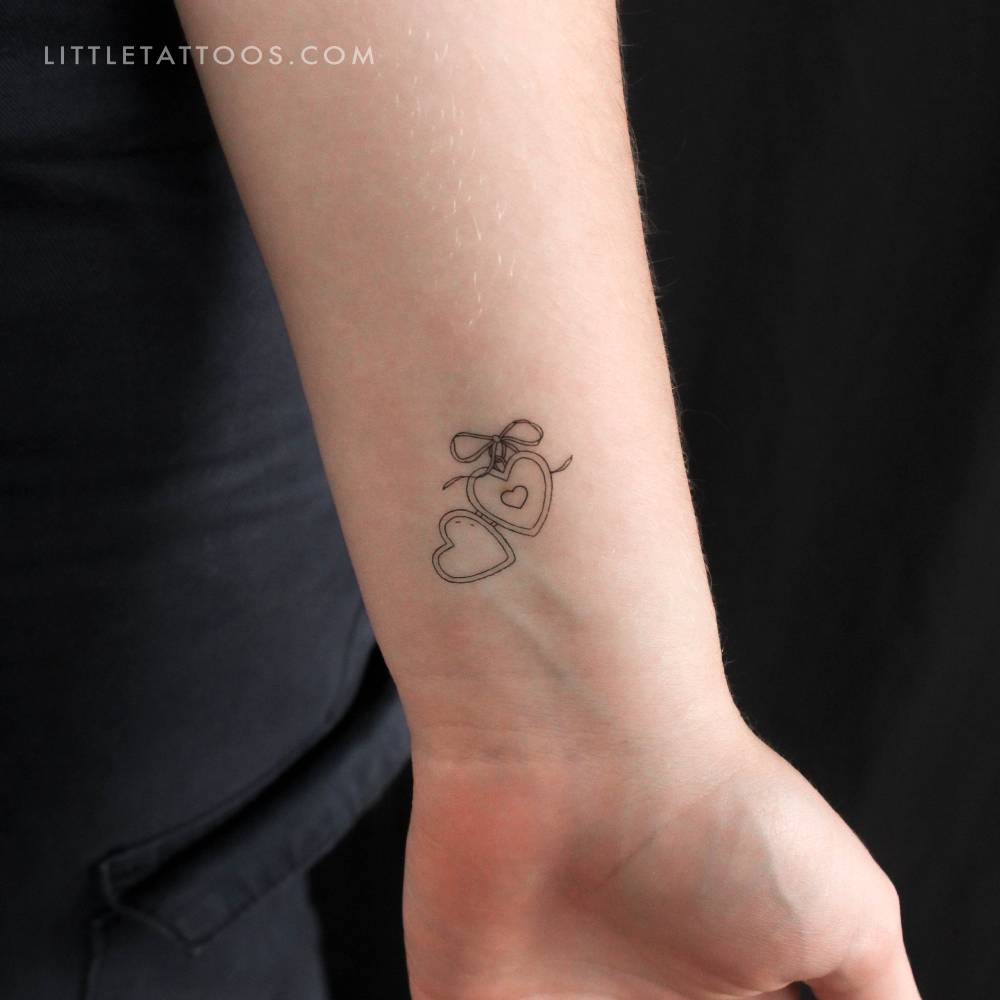 Small heart pendant temporary tattoo located on the wrist.