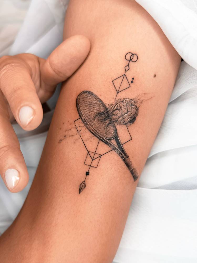 Tennis racquet tattoo in graphic style located on the upper arm.