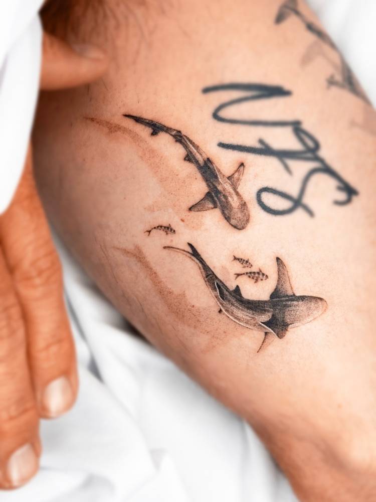 3d effect sharks tattooed on the inner forearm, micro-realistic style.