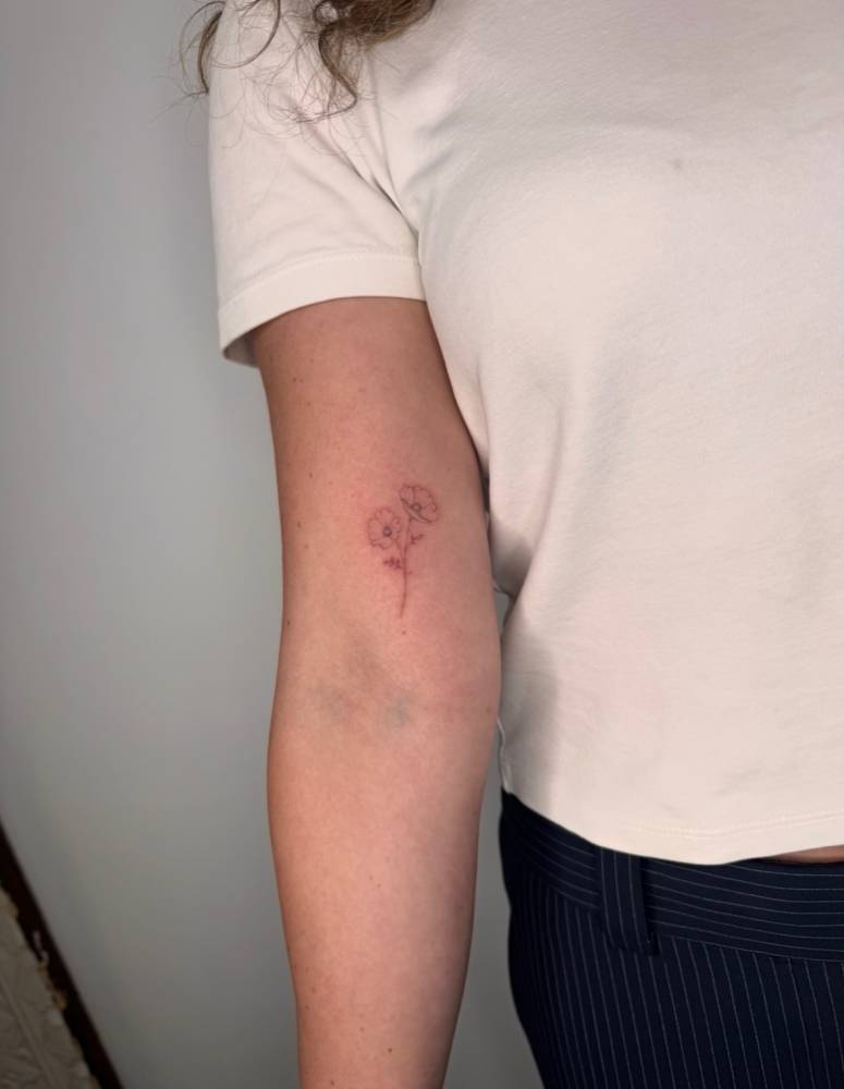 Single needle poppy flowers tattoo located on the inner arm.