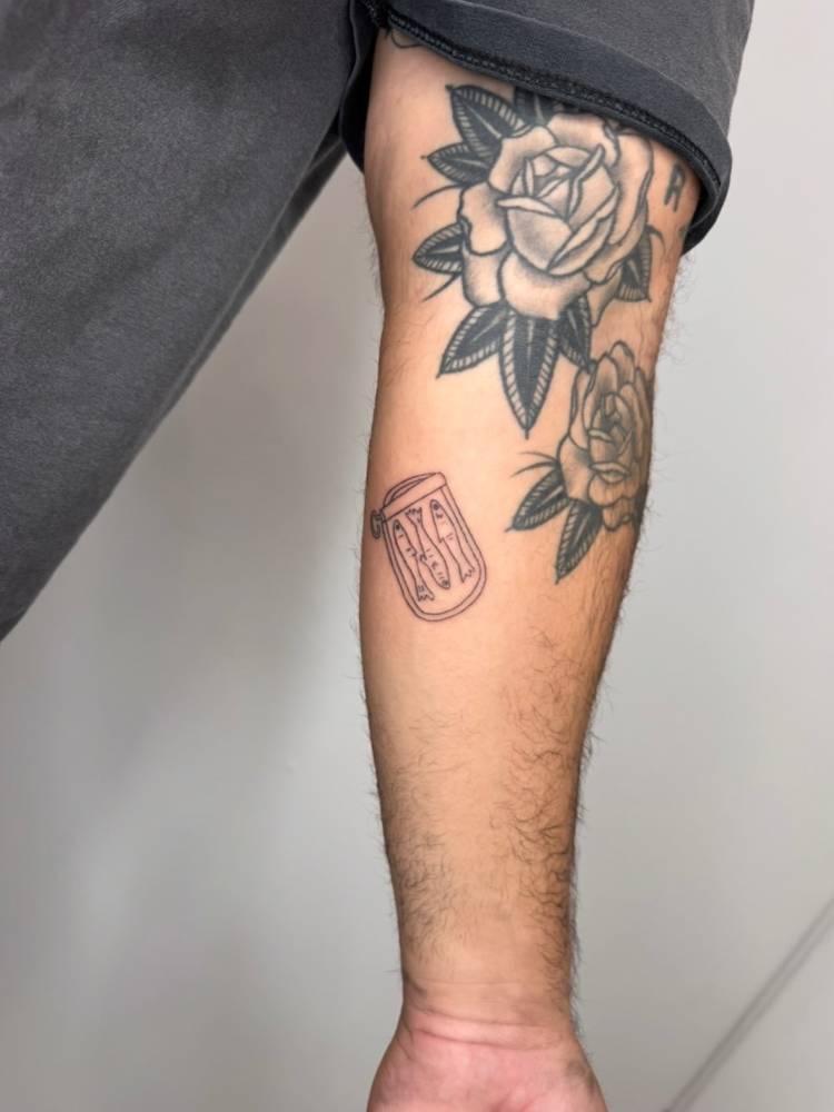 Canned sardines tattoo located on the inner forearm.