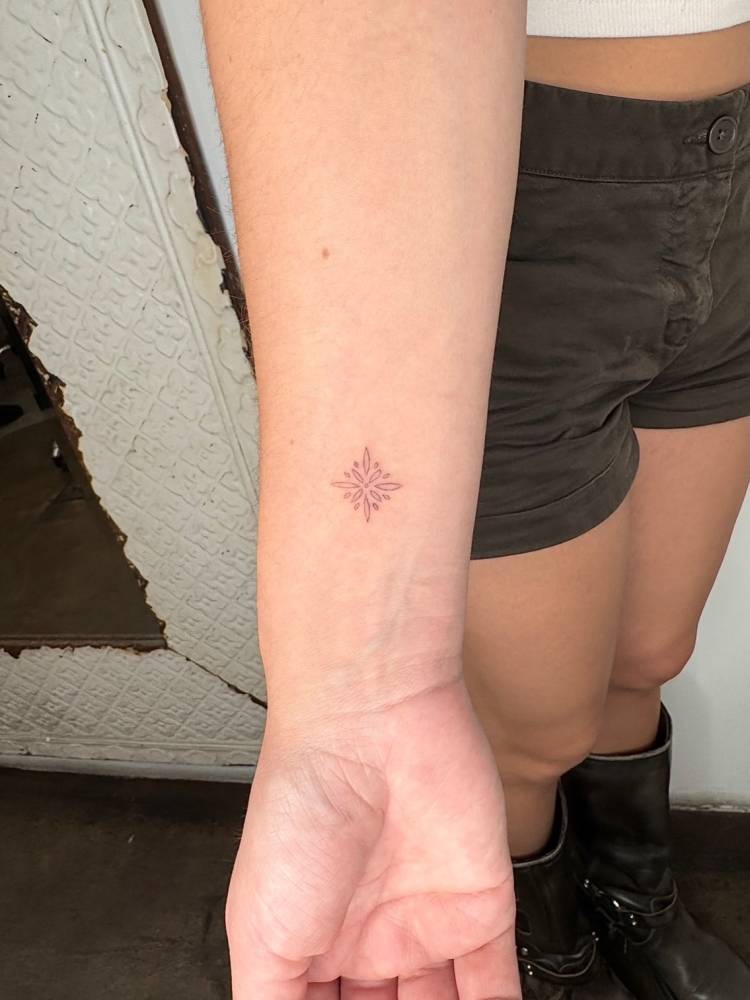 Little ornamental design in fine line style placed on the wrist.
