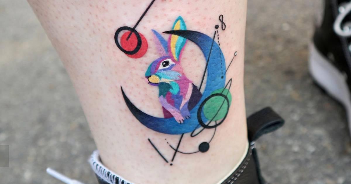 Graphic style rabbit and crescent moon tattoo located