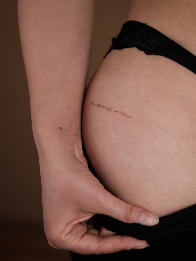 Handwritten font word "amore" and tiny heart tattoos.