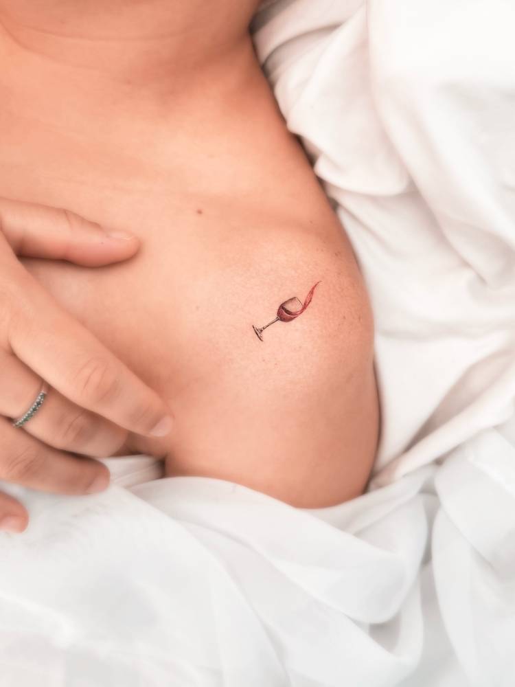 Micro-realistic style wine glass tattoo done on the shoulder.