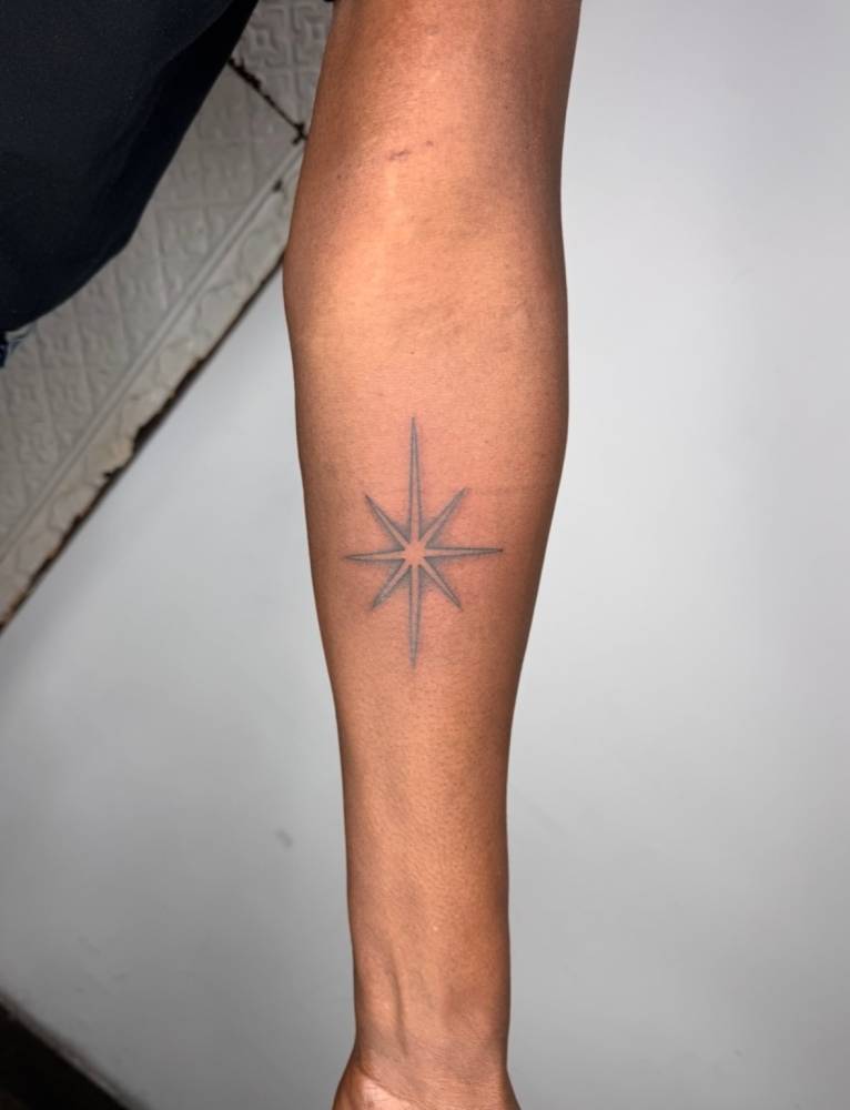 Illustrative style north star tattoo located on the inner forearm.